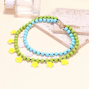 Bohemian multi-layer colorful beaded necklace with floral pendants on a stone display