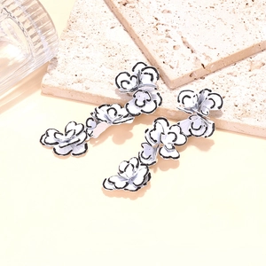 Elegant white enamel long floral earrings with black borders and tiered petal design