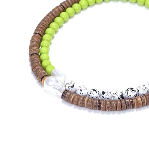 Détail d'un collier de perles en bois bohème orné d'une grande perle baroque lustrée