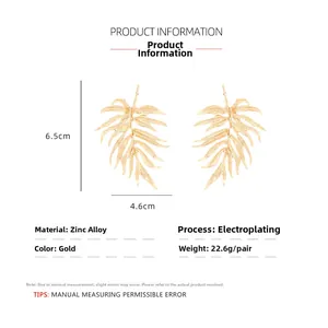 Macro detail of gold leaf earrings showing 6.5cm height and 4.6cm width dimensions
