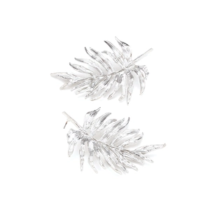 Macro detail of silver leaf drop earrings showing intricate 3D textures and metallic luster