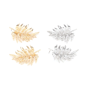 Golden and silver palm leaf stud earrings with detailed leaf texture on white background