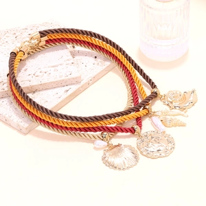 Gros plan du collier bohème à plusieurs rangs avec breloques coquillages dorés