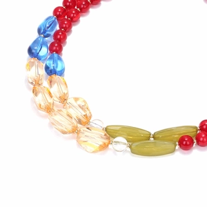 Détail de perles en résine colorées à finition brillante sur un collier multicouche