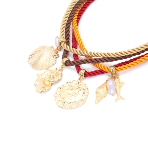 Détail de cordes nautiques superposées avec pendentifs coquillage et poisson