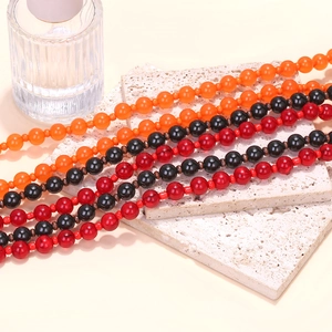 Macro shot of Halloween layered beaded necklaces in orange, black, and red tones