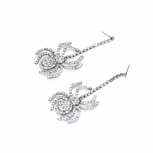 Macro shot of silver spider earrings with sparkling rhinestones and long tassel chain
