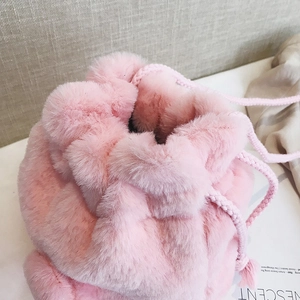 Pink plush drawstring bucket bag with soft faux fur texture for women's winter fashion