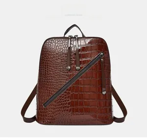 Front detail of dark brown backpack in embossed crocodile leather with metal zippers
