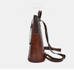Side view of dark brown crocodile pattern backpack with adjustable straps and side zipper