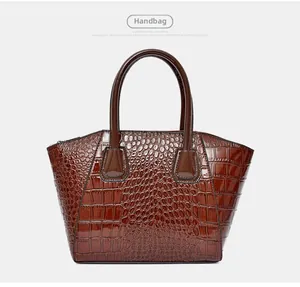 Detail view of the deep brown crocodile-embossed leather texture on a stylish handbag