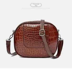 Detailed close-up of brown crocodile pattern shoulder bag with polished finish