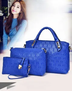 Detailed view of the 3-piece blue handbag set with textured surface and gold hardware