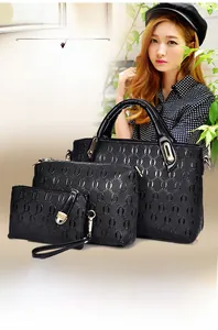 Close-up of black textured three-piece handbag set with golden hardware and chain patterns
