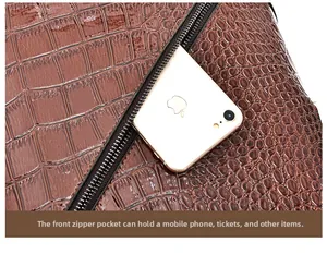 Detail of the brown crocodile pattern bag with a functional front zipper pocket for a phone