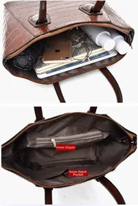 Detailed interior of brown crocodile embossed tote showing zipper and inner patch pockets