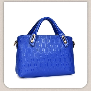 Front view of blue Boston bag with textured oval embossing and gold metal zippers