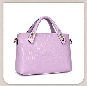 Detail of lavender handbag featuring embossed oval chain texture and gold hardware