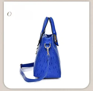 Side view of royal blue patent leather handbag with textured chain link pattern