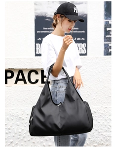 Detail of black waterproof nylon fitness bag with wide shoulder strap for sport travel