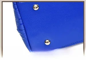 Detail view of electric blue leather handbag base with protective gold metal rivets