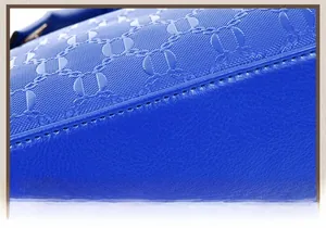 Detailed close-up of royal blue leather handbag showing grid texture and fine stitching