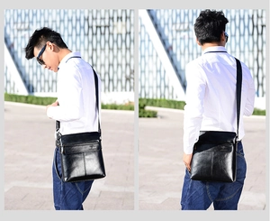 Detailed view of black vertical men's shoulder bag with embossed kangaroo logo
