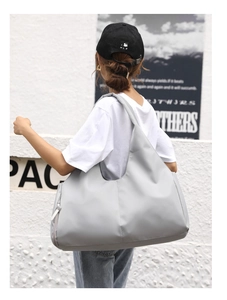 Close-up of lightweight grey gym bag featuring a large capacity and wide shoulder strap