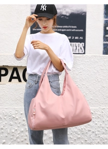 Detailed view of pink sports duffel bag featuring a side zipper pocket and nylon fabric
