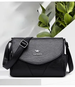 Détail du sac bandoulière en cuir grainé noir avec logo argenté et sangle réglable