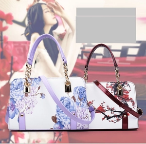 Detail of floral PU leather handbags in purple rose and red plum blossom prints