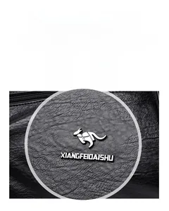 Détail du cuir à texture litchi imperméable avec logo de marque argenté sur le sac