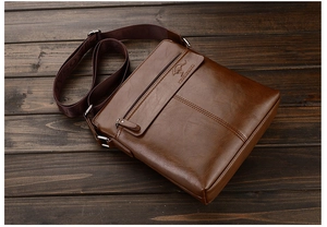 Close-up of brown leather shoulder bag featuring embossed kangaroo logo on wood background