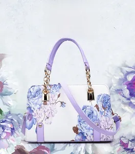 Detail of floral printed handbag with purple handle and gold chain hardware