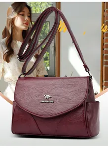 Détail d'un sac bandoulière bordeaux en similicuir grainé avec logo métallique