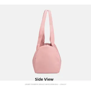 Side view of pink sports bag showing durable waterproof nylon fabric and wide strap