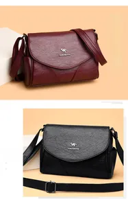 Détail de la texture en cuir grainé doux sur sacs bandoulière noirs et bordeaux