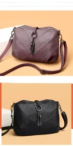 Détails des sacs bandoulière en violet et noir avec coutures en V et pompons métalliques