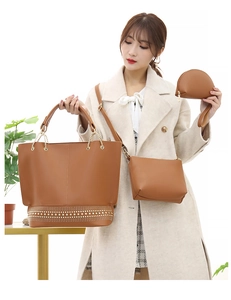 Dettaglio del set di borse in pelle marrone con borchie dorate indossate da una modella