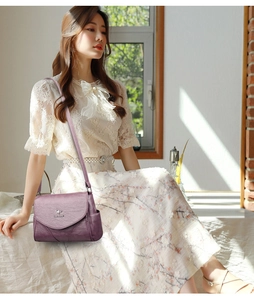 Détail du sac à bandoulière en cuir souple violet avec logo kangourou en métal