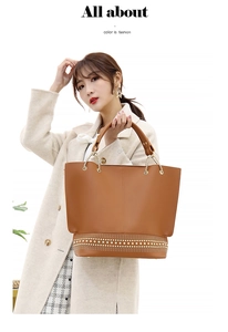 Dettaglio borsa tote marrone con borchie dorate e manici eleganti in catena metallica