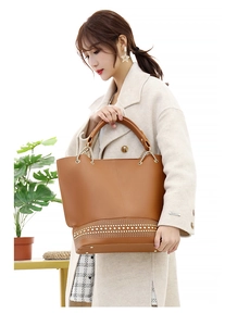 Dettaglio borsa shopper marrone con borchie metalliche e manici a catena moda