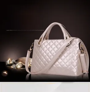 Close-up of pearl white quilted handbag with glossy finish and gold metal hardware