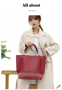 Dettaglio della borsa tote in pelle opaca rossa con rivetti dorati decorativi e manici