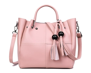 Detail der rosa Kunstleder-Eimertasche mit Quastenanhängern und Umhängeriemen