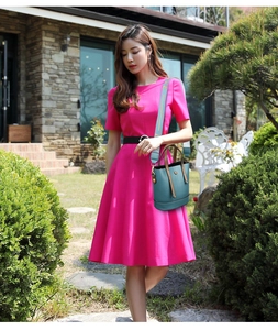 Outdoor street style view of a teal bucket bag with a wide LOVE lettered strap and short handle