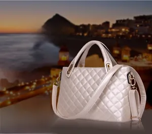 Close-up of pearl champagne quilted shoulder bag with golden hardware and top handle