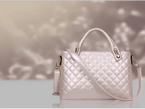 Detail view of pearlescent quilted crossbody bag with golden hardware and chain strap