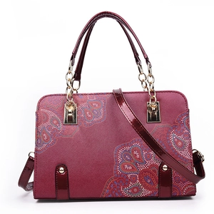 Burgundy paisley print faux leather handbag with gold chain handles and cross strap