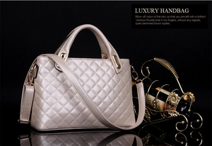 Close-up of champagne beige quilted shoulder bag with metal buckle and chain strap